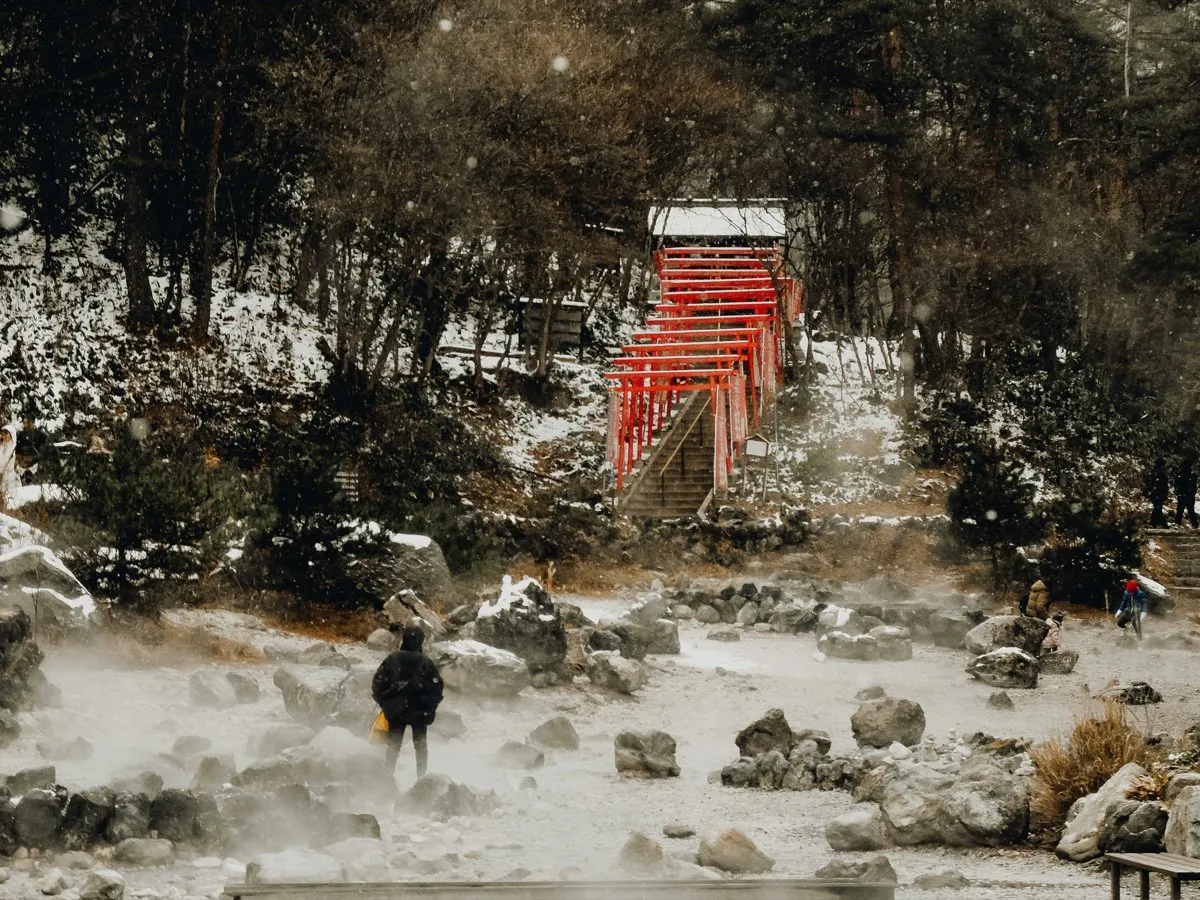Parque geotérmico de Sainokawara con torii rojos y manantiales humeantes en Kusatsu